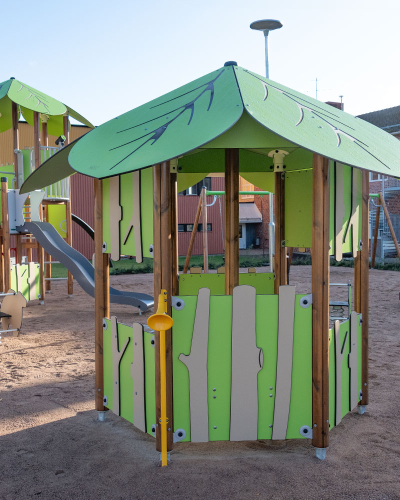 Jungle themed playground unit with panels resembling trees, leaves and tree canopy.